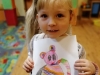 Na zdjęciu dziewczynka trzymająca obrazek misia