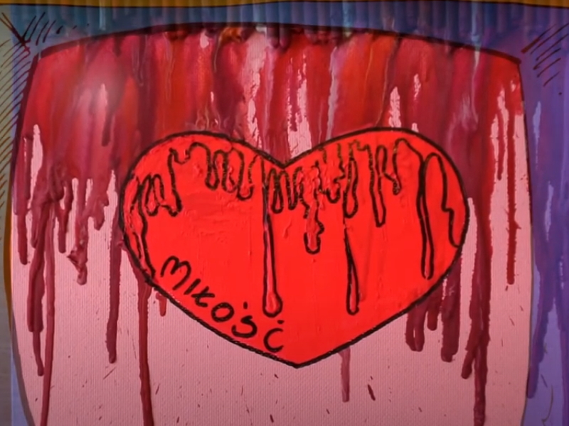 czerwone serce z napisem miłość narysowane na podkładce na której widać stopione kredki