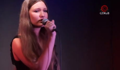 dziewczyna w długich włosach z mikrofonem na scenie