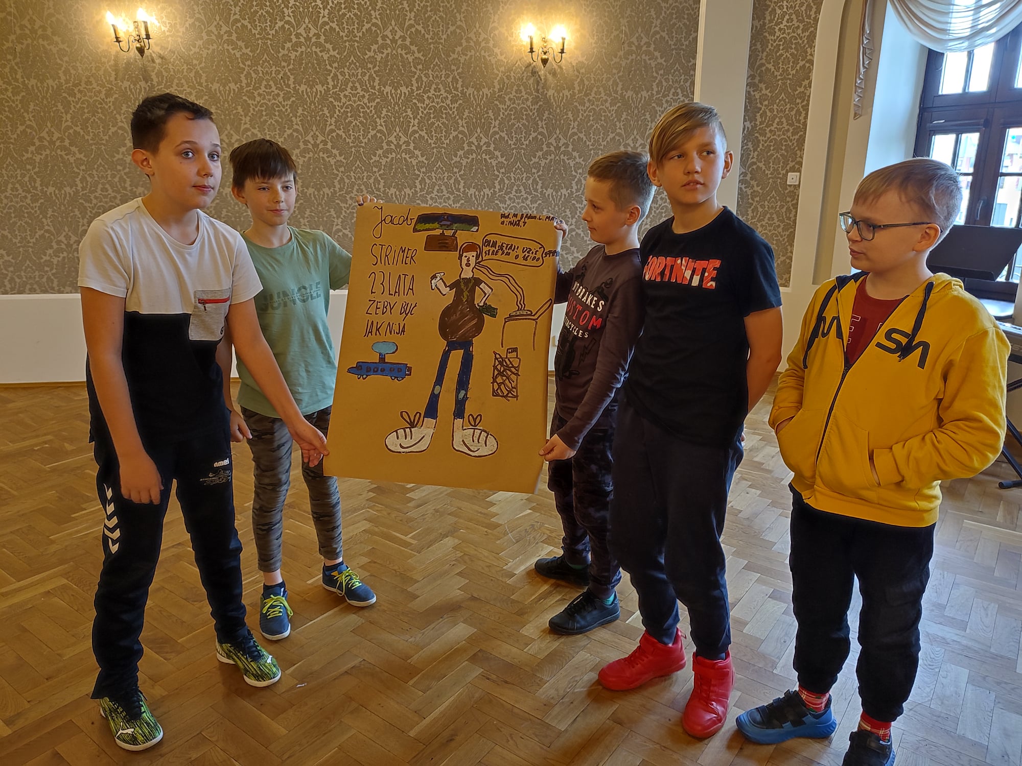 Pięciu chłopców prezentuje swój plakat