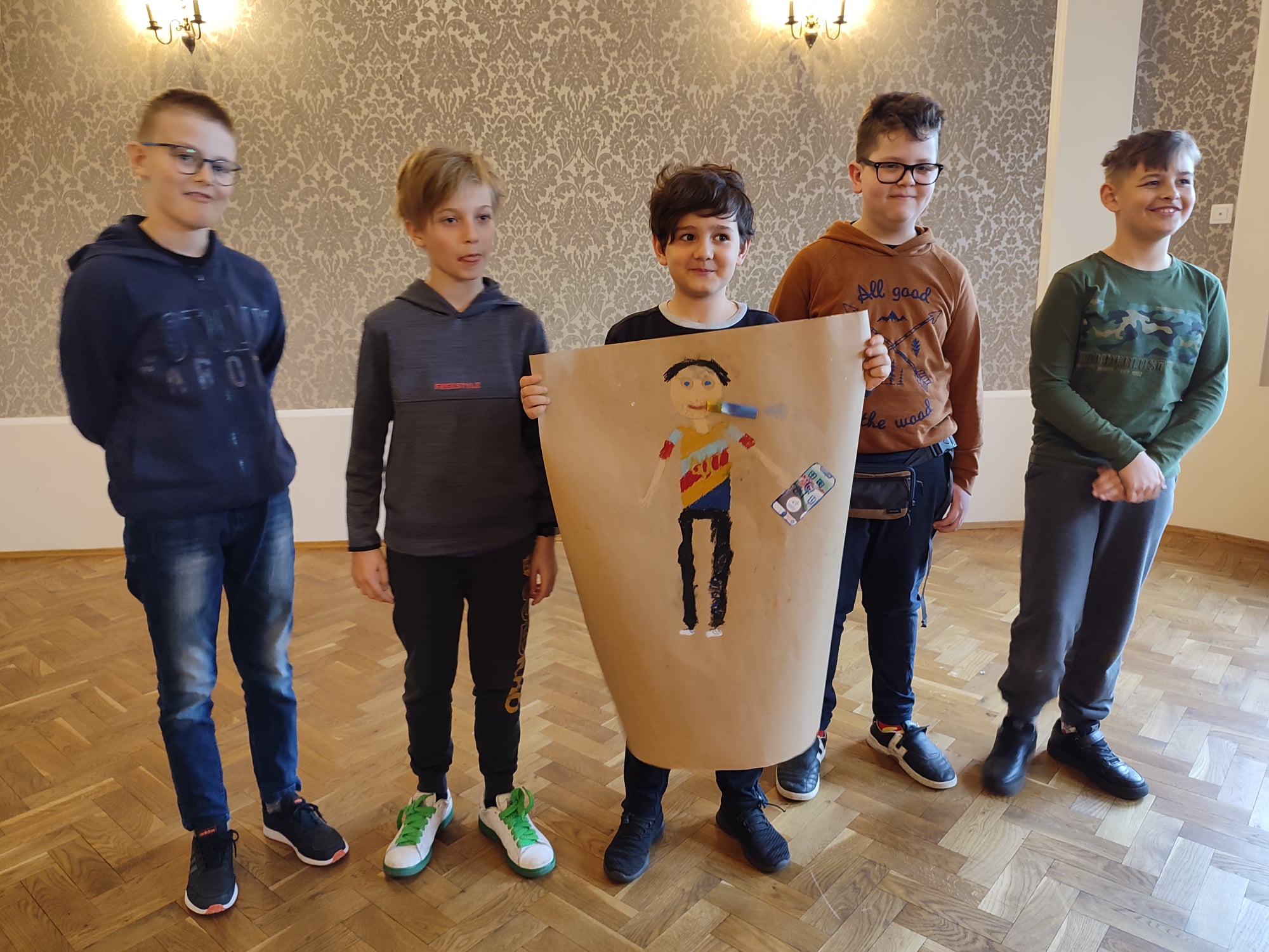 Pięciu chłopców prezentuje swój plakat