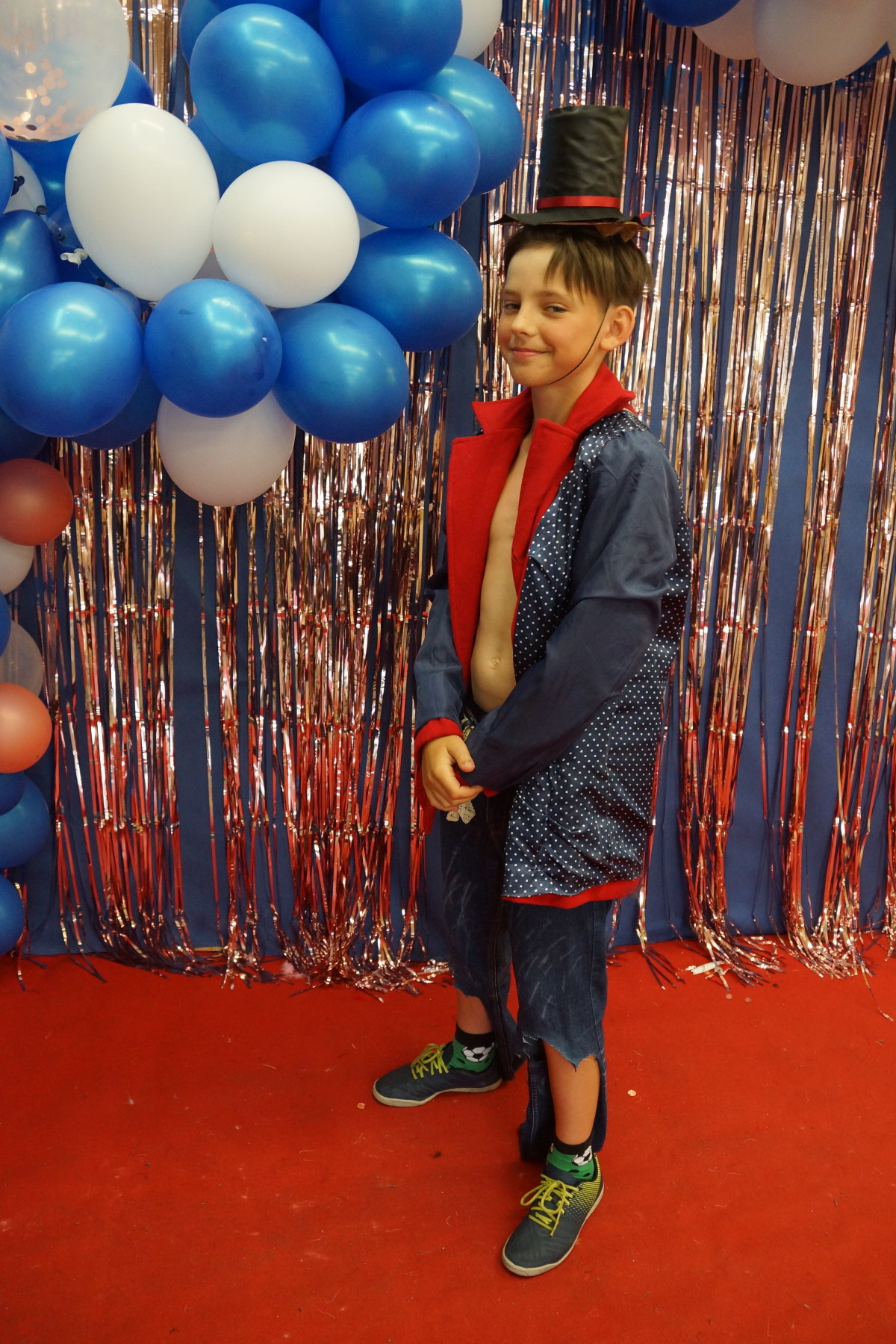 chłopiec w wymyślonym przez siebie stroju na tle kolorowych balonów