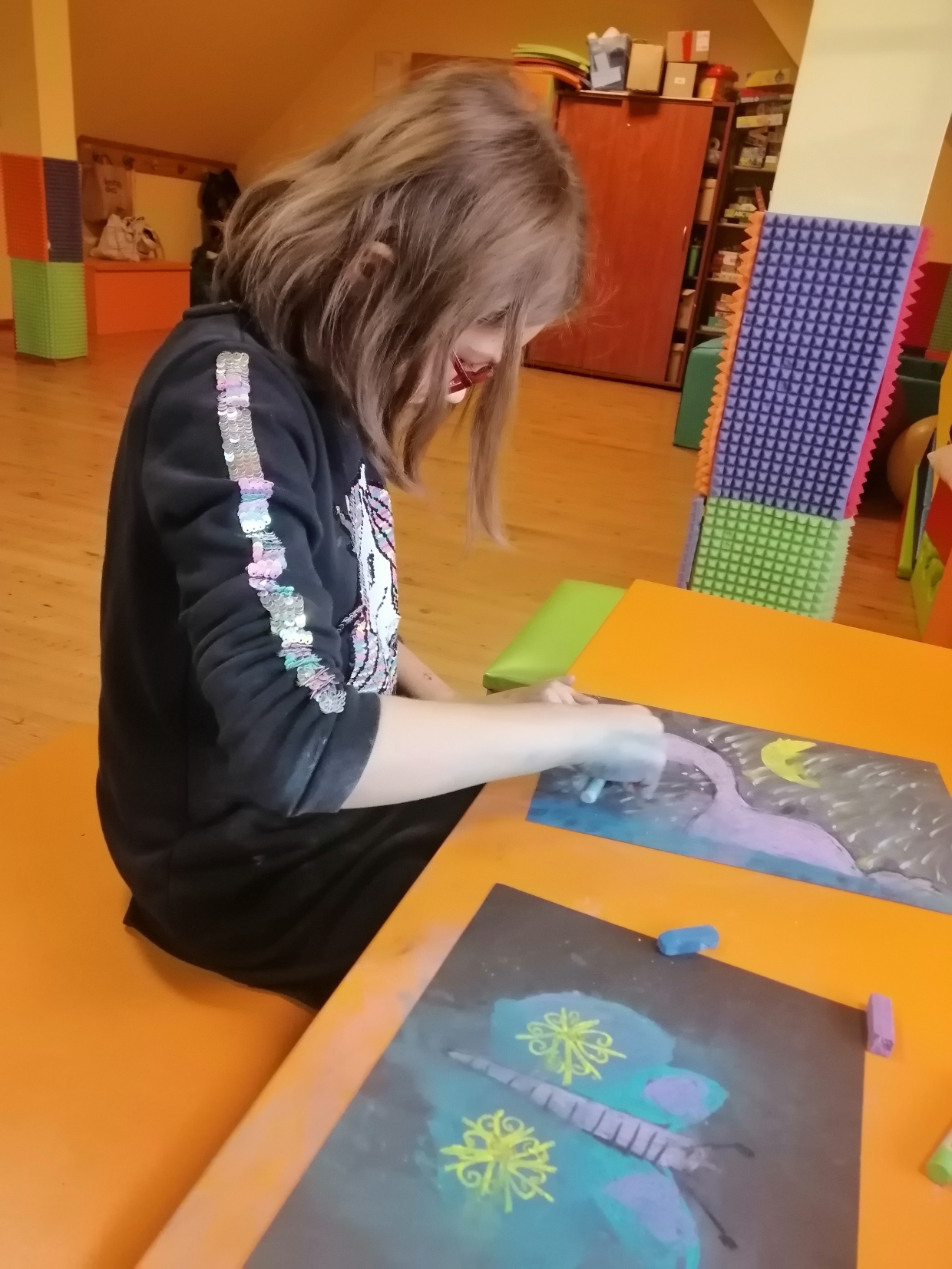 dziewczynka koloruje obrazek suchymi pastelami